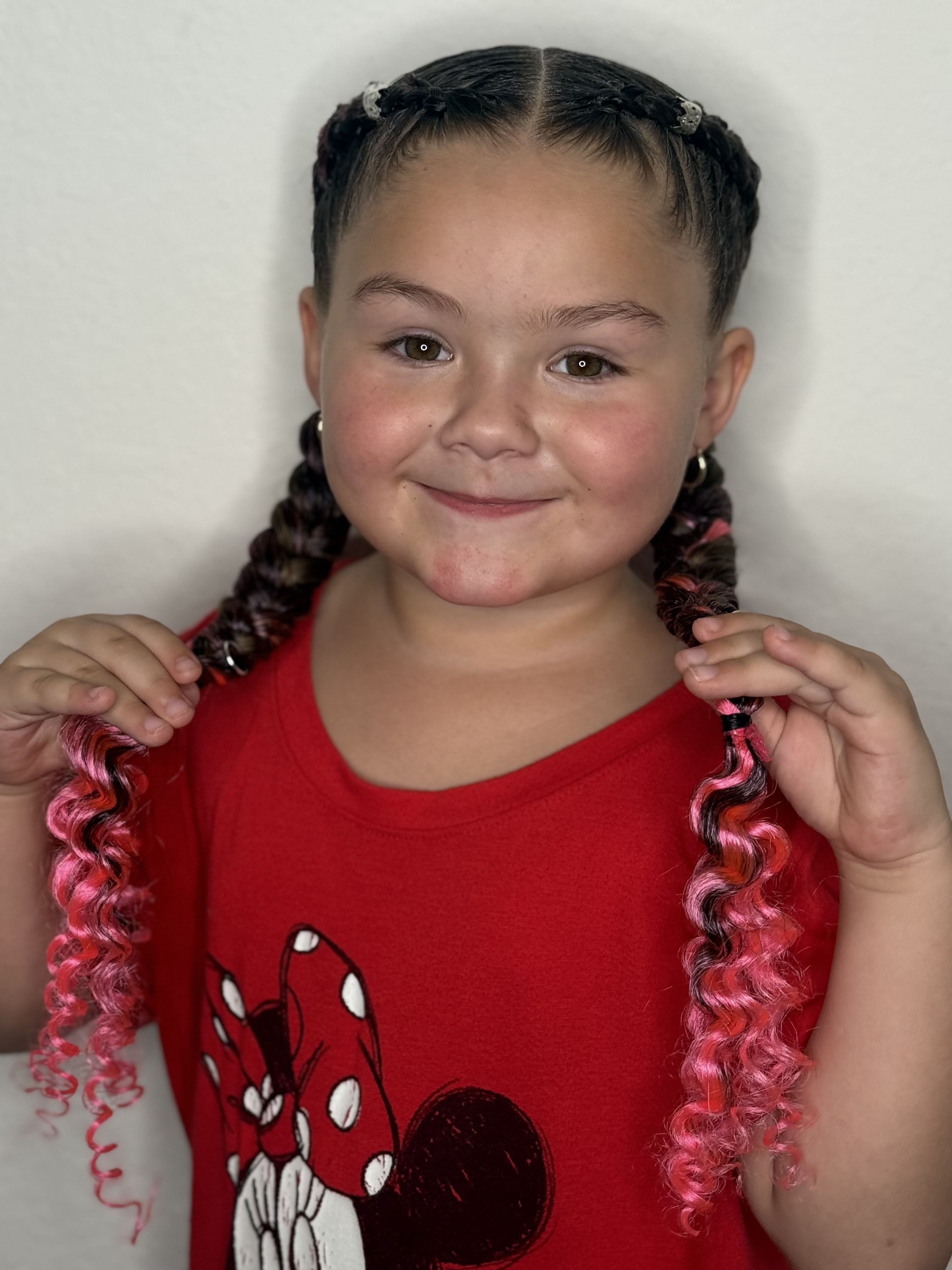 Nina sonriendo con trenzas rosadas por Yulis en South Miami